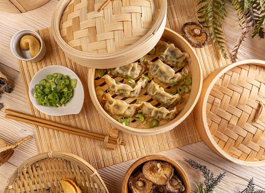 Dong Bei dumplings served in a bamboo basket, topped with fresh green onions, perfect for a traditional Dong Bei dumpling recipe.